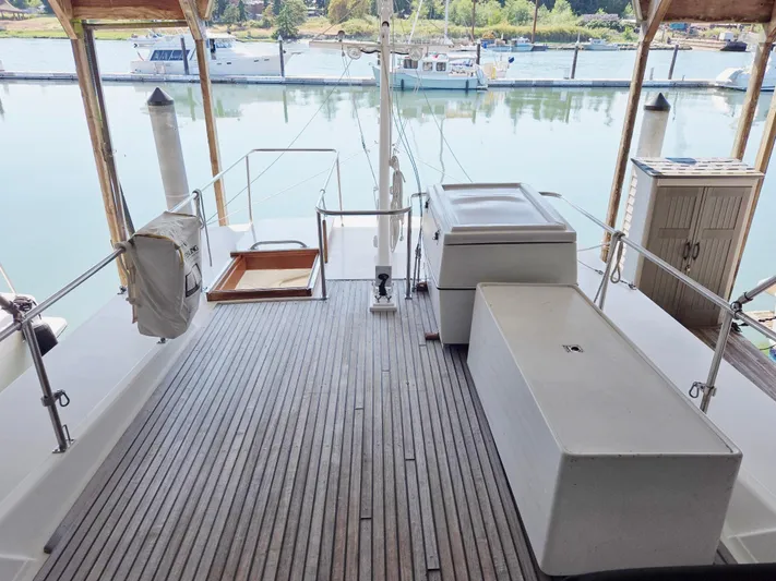 Carina Yacht Photos Pics 1990 Grand Banks 36 Europa yacht deck with wooden flooring, docked at a marina.