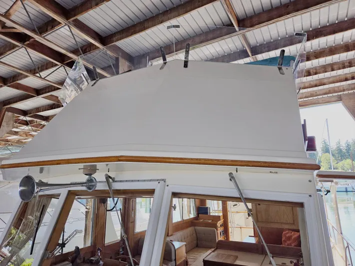 Carina Yacht Photos Pics 1990 Grand Banks 36 Europa yacht interior under covered dock, showcasing helm and seating area.