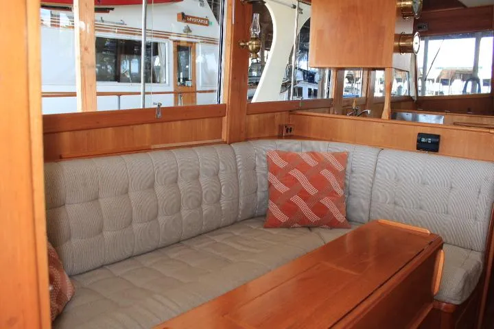 Carina Yacht Photos Pics Cozy interior of 1990 Grand Banks 36 Europa yacht with cushioned seating and wooden accents.