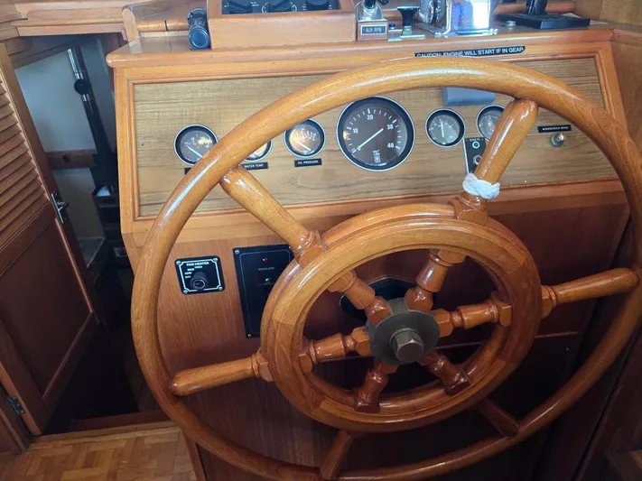 Carina Yacht Photos Pics Wooden helm of a 1990 Grand Banks 36 Europa boat with gauges and controls.