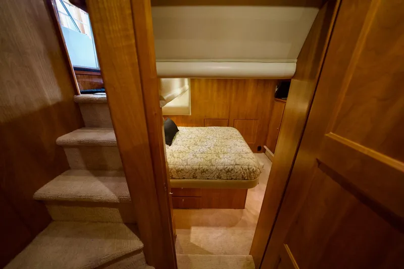 Nautilus Yacht Photos Pics Cozy bedroom interior of 2008 Navigator 5100 yacht with wooden finish and stairs.