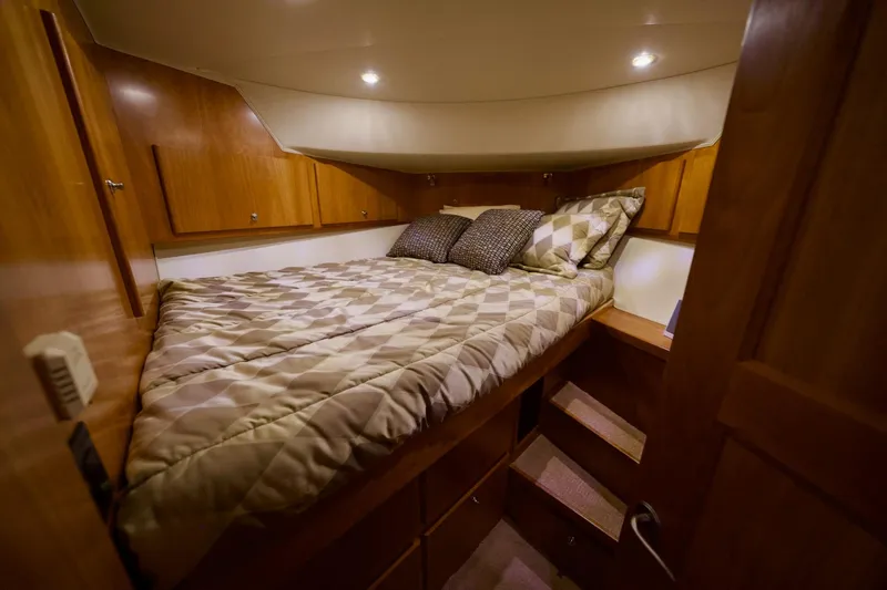 Nautilus Yacht Photos Pics Cozy bedroom in 2008 Navigator 5100 yacht with wooden cabinets and patterned bedding.