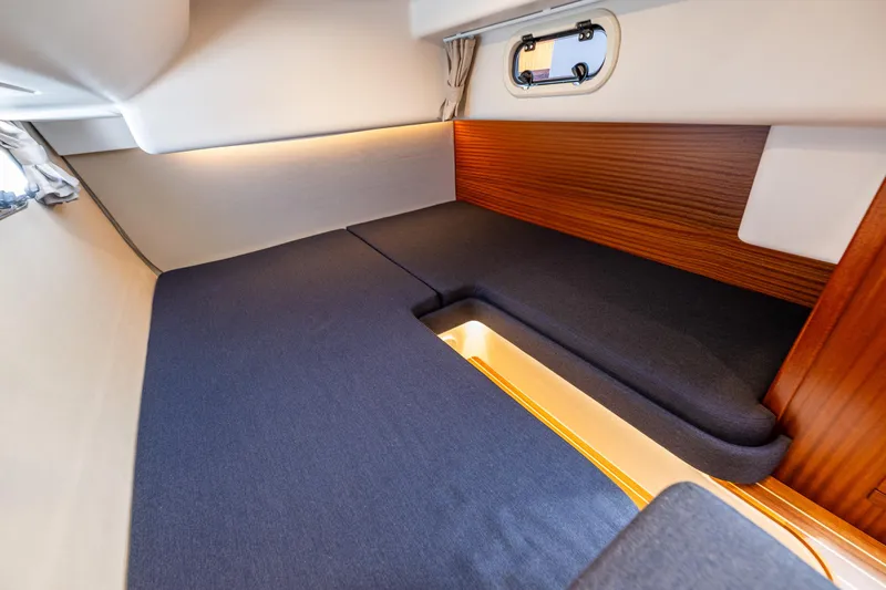  Yacht Photos Pics Interior cabin of 2021 Nimbus 405 Coupé, featuring cozy bedding and wooden accents.