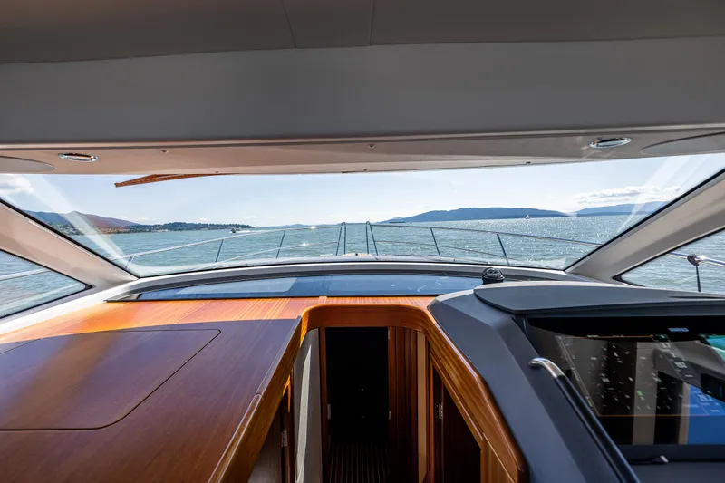  Yacht Photos Pics Interior view from a 2021 Nimbus 405 Coupé yacht, overlooking the sea and distant mountains.