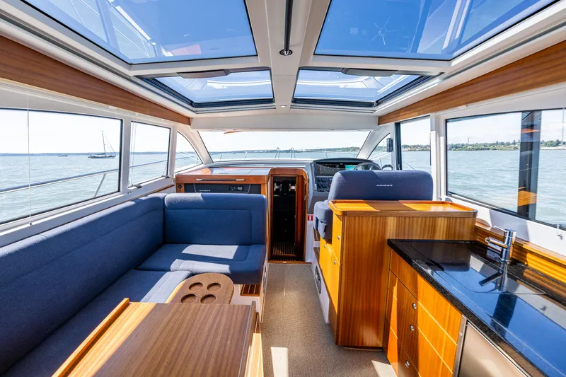  Yacht Photos Pics Luxurious interior of 2021 Nimbus 405 Coupé yacht with panoramic windows and elegant wood finishes.