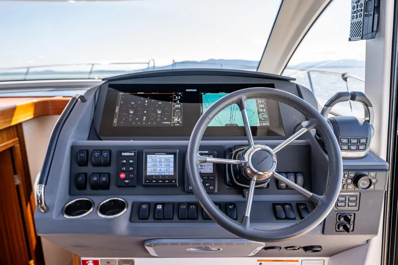  Yacht Photos Pics Steering wheel and dashboard of 2021 Nimbus 405 Coupé yacht, featuring navigation controls.