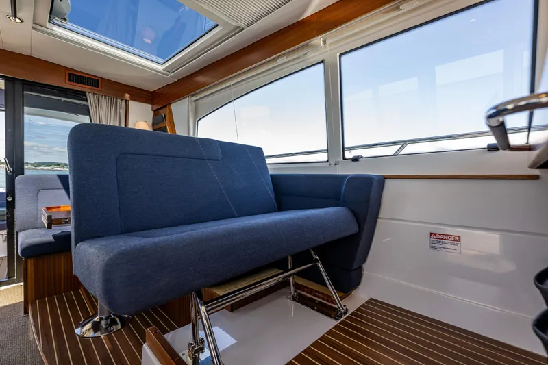 Yacht Photos Pics Interior of 2021 Nimbus 405 Coupé #88, featuring blue seating and large windows.