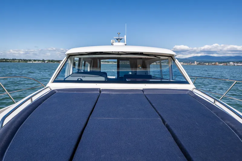  Yacht Photos Pics Nimbus 405 Coupé #88, 2021 model, cruising on a serene lake under a clear blue sky.
