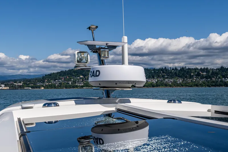  Yacht Photos Pics Nimbus 405 Coupé #88, 2021 model, cruising on a lake with scenic forested hills.