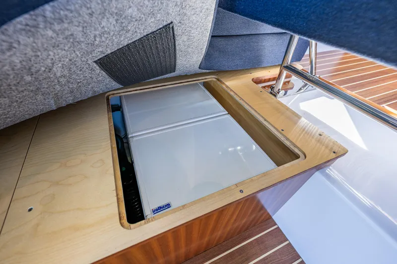  Yacht Photos Pics Under-seat storage compartment in a 2021 Nimbus 405 Coupé boat, featuring a built-in refrigerator.