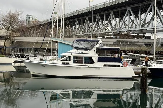 "sarona Ii" Yacht Photos Pics 1994 Tollycraft 45 Cockpit Motor Yacht docked under a bridge, reflecting on calm water.