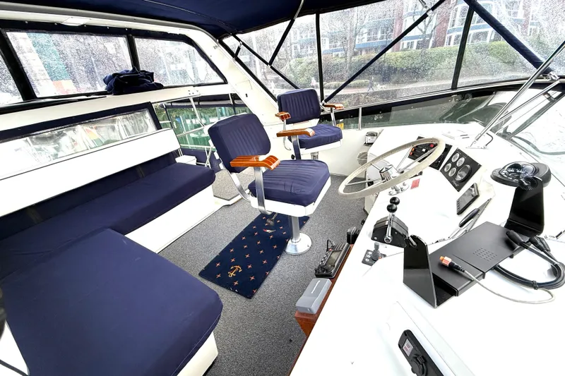 "sarona Ii" Yacht Photos Pics 1994 Tollycraft 45 Cockpit Motor Yacht interior with blue seating and helm station.