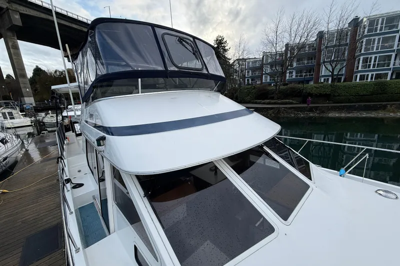 "sarona Ii" Yacht Photos Pics 1994 Tollycraft 45 Cockpit Motor Yacht docked near modern buildings.