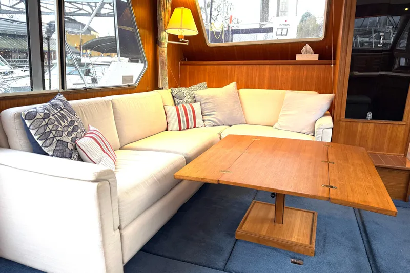 "sarona Ii" Yacht Photos Pics Luxurious interior of 1994 Tollycraft 45 Cockpit Motor Yacht with cozy seating and wooden table.