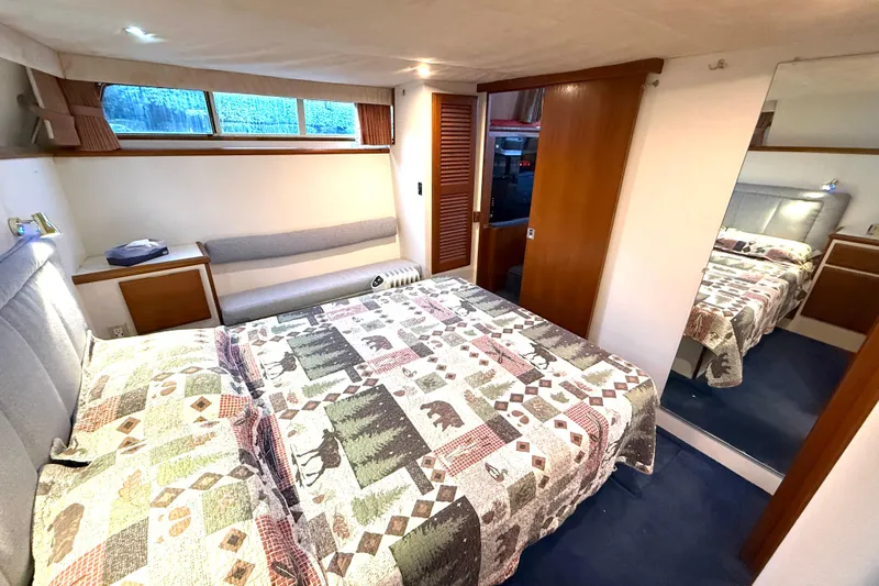 "sarona Ii" Yacht Photos Pics Bedroom interior of 1994 Tollycraft 45 Cockpit Motor Yacht with patterned bedding and wood accents.