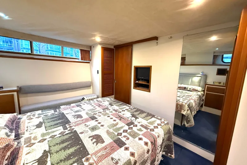"sarona Ii" Yacht Photos Pics 1994 Tollycraft 45 Cockpit Motor Yacht bedroom with patterned bedding and wooden accents.