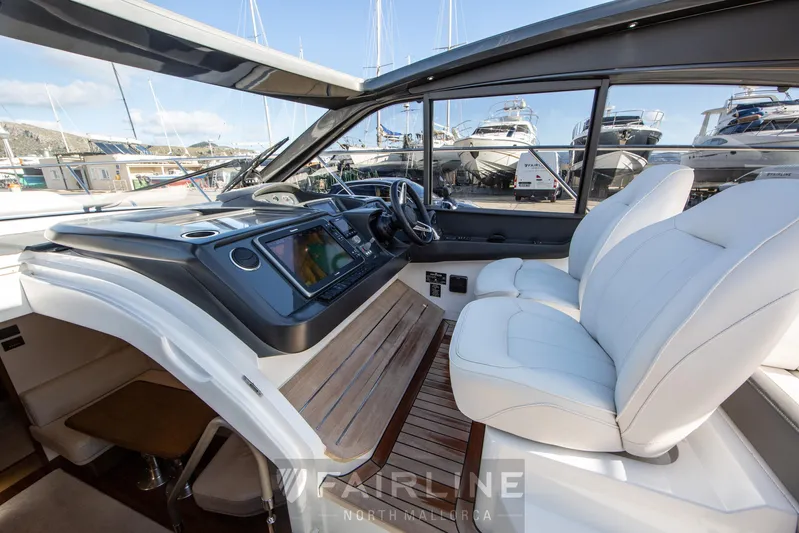  Yacht Photos Pics Interior view of 2017 Princess V48 Open yacht with modern dashboard and seating.