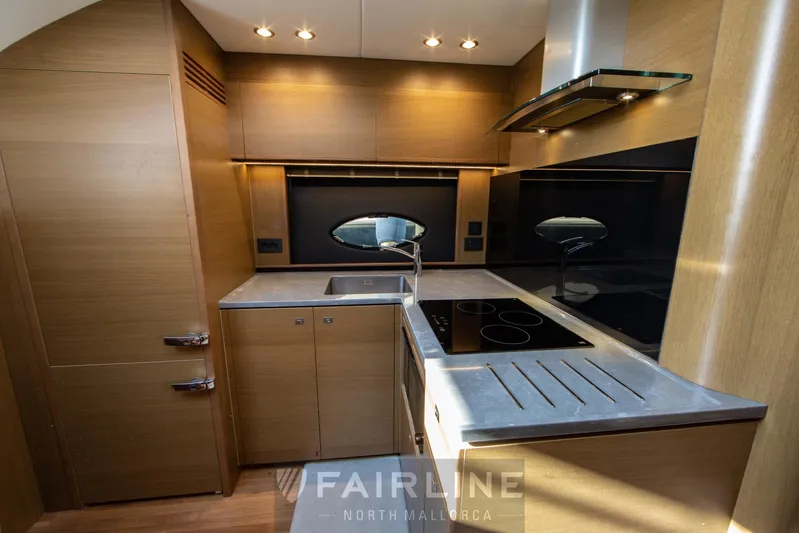  Yacht Photos Pics Modern kitchen interior of 2017 Princess V48 Open yacht, featuring sleek wood cabinetry.