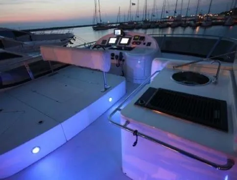  Yacht Photos Pics 2009 Uniesse 58 yacht deck at sunset, featuring illuminated controls and seating.