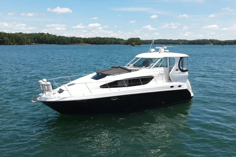  Yacht Photos Pics 2007 Sea Ray 40 Motor Yacht on a serene lake under a clear blue sky.