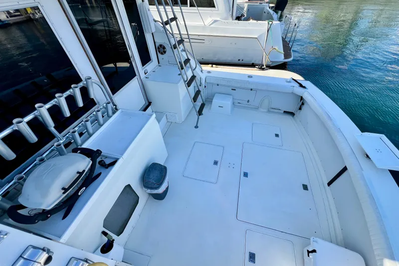 Live Wire Yacht Photos Pics 1982 Bertram 46 Convertible boat deck with fishing rod holders and ladder.
