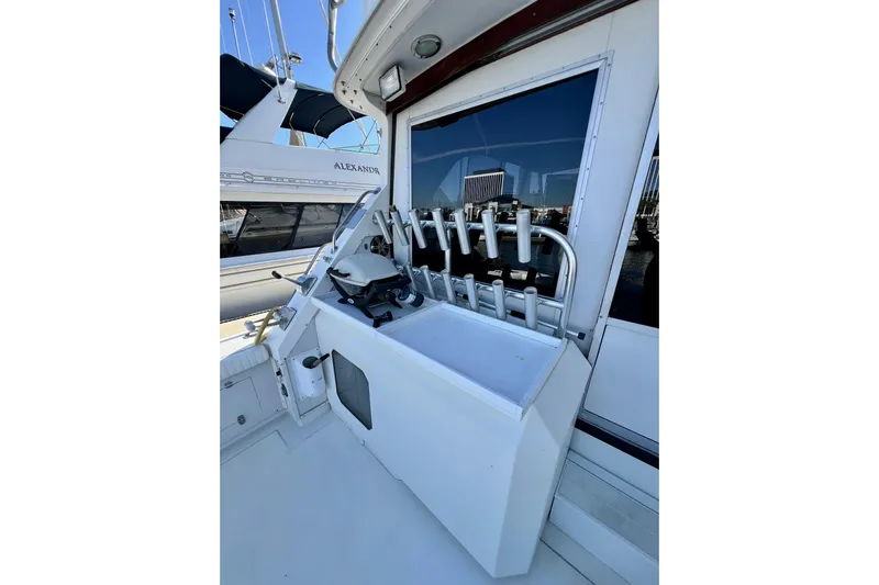 Live Wire Yacht Photos Pics 1982 Bertram 46 Convertible yacht deck with fishing rod holders and equipment storage.