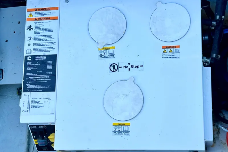 Live Wire Yacht Photos Pics Engine compartment of a 1982 Bertram 46 Convertible with warning labels and "No Step" sign.