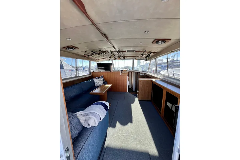 Live Wire Yacht Photos Pics Interior of 1982 Bertram 46 Convertible yacht with cozy seating and fishing rods.