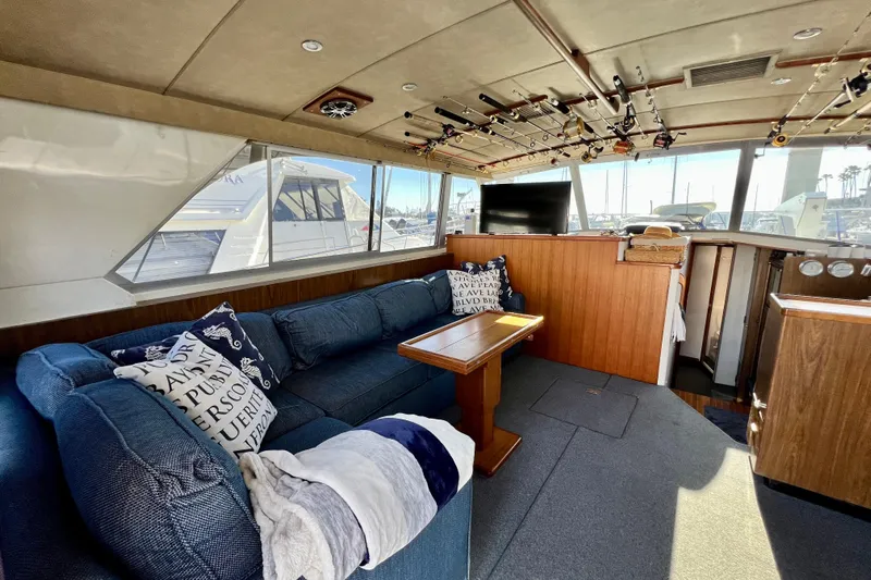 Live Wire Yacht Photos Pics Interior of 1982 Bertram 46 Convertible yacht with cozy seating and fishing rods.
