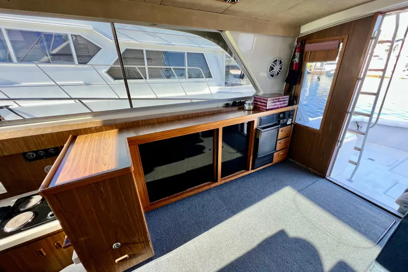 Live Wire Yacht Photos Pics Interior of 1982 Bertram 46 Convertible yacht with wood cabinetry and large windows.