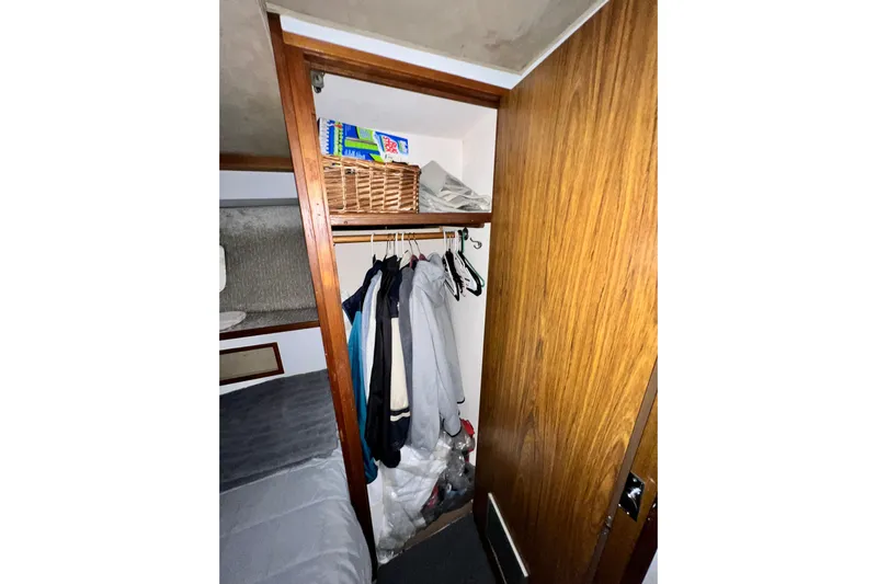 Live Wire Yacht Photos Pics Closet interior on 1982 Bertram 46 Convertible yacht with hanging clothes and storage basket.