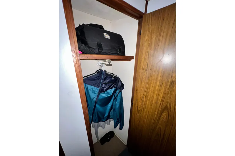 Live Wire Yacht Photos Pics Closet interior on 1982 Bertram 46 Convertible with hanging clothes and a bag.