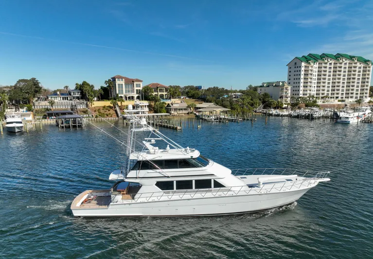 Pole Position Yacht Photos Pics 1997 Hatteras Sportfish yacht cruising near waterfront properties.