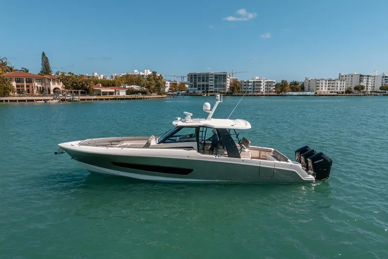 Pipe Dream Yacht Photos Pics 2023 Boston Whaler 420 Outrage boat cruising on a sunny day in a coastal city.
