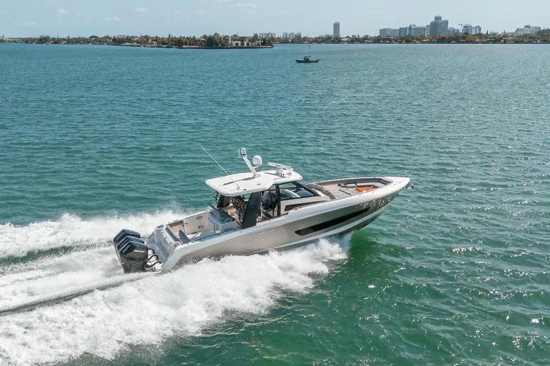 Pipe Dream Yacht Photos Pics 2023 Boston Whaler 420 Outrage cruising on open water, city skyline in background.