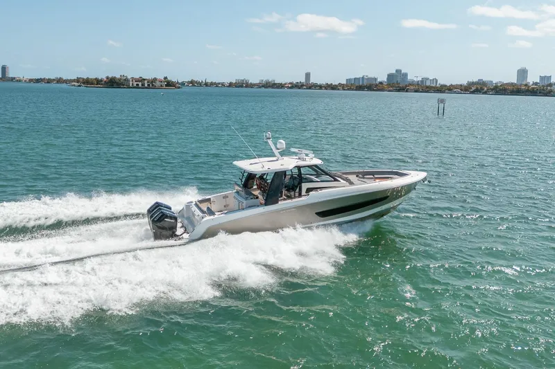 Pipe Dream Yacht Photos Pics 2023 Boston Whaler 420 Outrage cruising on open water with city skyline backdrop.