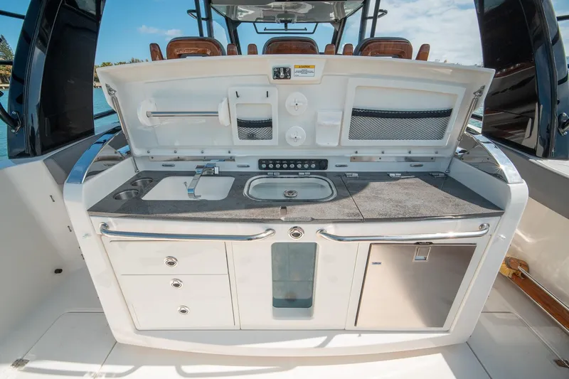 Pipe Dream Yacht Photos Pics 2023 Boston Whaler 420 Outrage boat kitchen with sink, storage, and countertop.