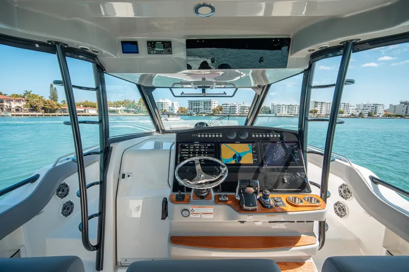 Pipe Dream Yacht Photos Pics 2023 Boston Whaler 420 Outrage helm with advanced navigation system, cruising in sunny waters.