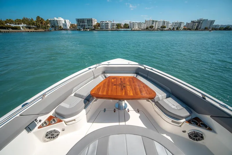 Pipe Dream Yacht Photos Pics 2023 Boston Whaler 420 Outrage boat interior with elegant seating and wooden table on calm water.