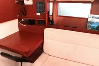 Interior of 2017 Hanse 455 yacht with wooden table and beige seating.
