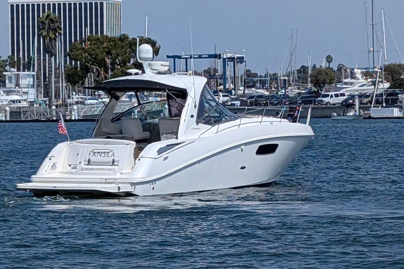 Fansea Yacht Photos Pics 2009 Sea Ray 350 Sundancer yacht cruising in a marina with cityscape background.