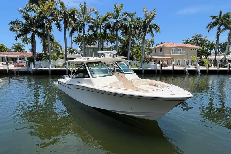V5 Yacht Photos Pics 2019 Grady-White Freedom 375 boat docked near waterfront homes and palm trees.