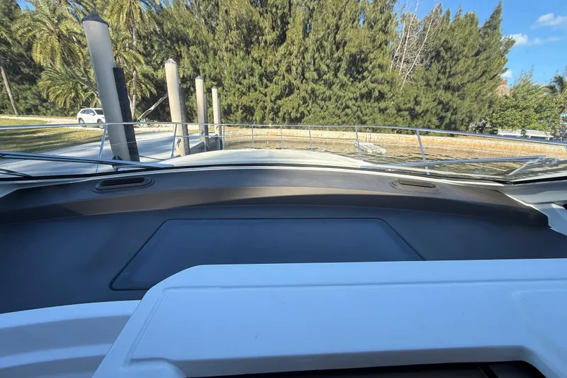  Yacht Photos Pics View from the helm of a 2018 Azimut Atlantis 43 yacht, docked near trees.
