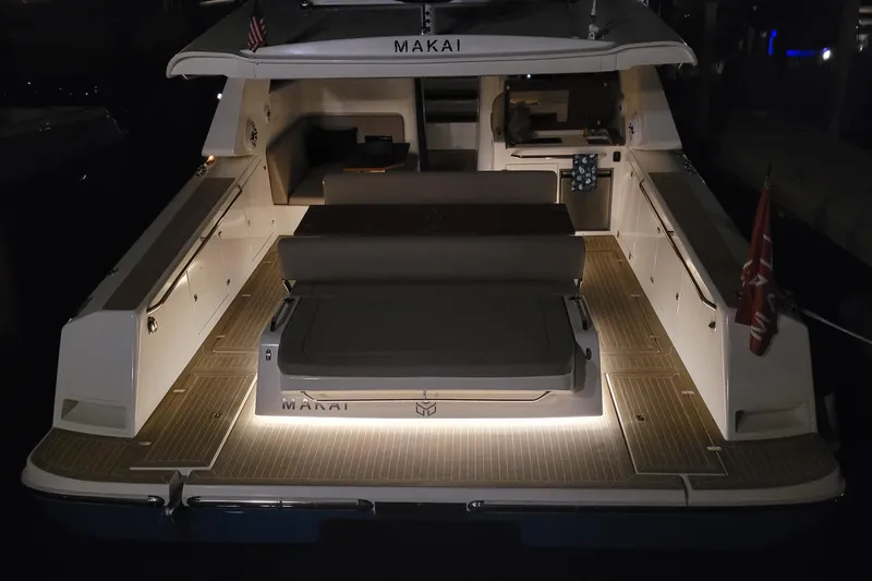  Yacht Photos Pics Sleek 2025 Makai M37 yacht with illuminated deck and modern seating at night.