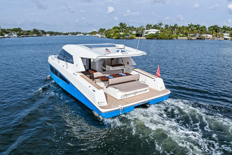  Yacht Photos Pics 2025 Makai M37 yacht cruising on a scenic waterway with lush greenery.