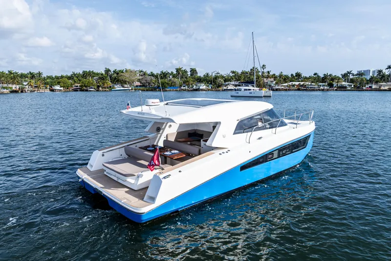  Yacht Photos Pics 2025 Makai M37 yacht cruising on a serene waterway with lush greenery in the background.