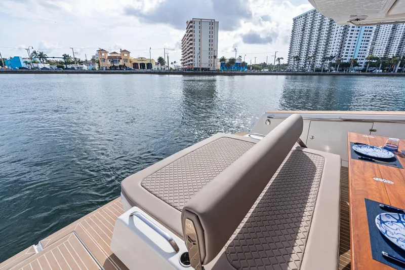  Yacht Photos Pics Luxury Makai M37 yacht deck with elegant seating, overlooking waterfront cityscape, 2025 model.