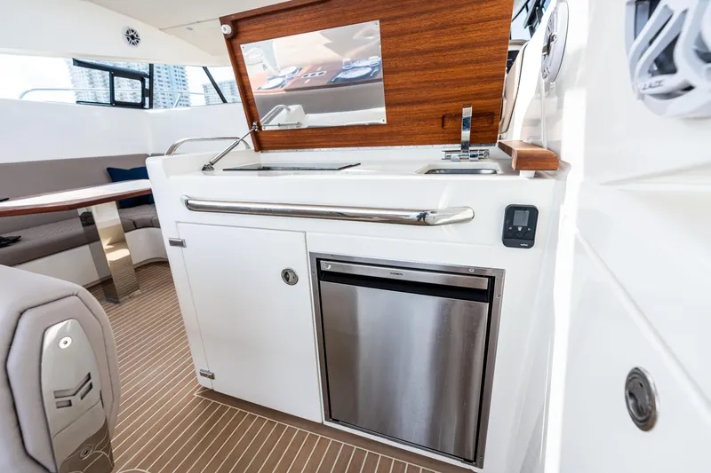  Yacht Photos Pics Modern interior of 2025 Makai M37 yacht with kitchenette and seating area.