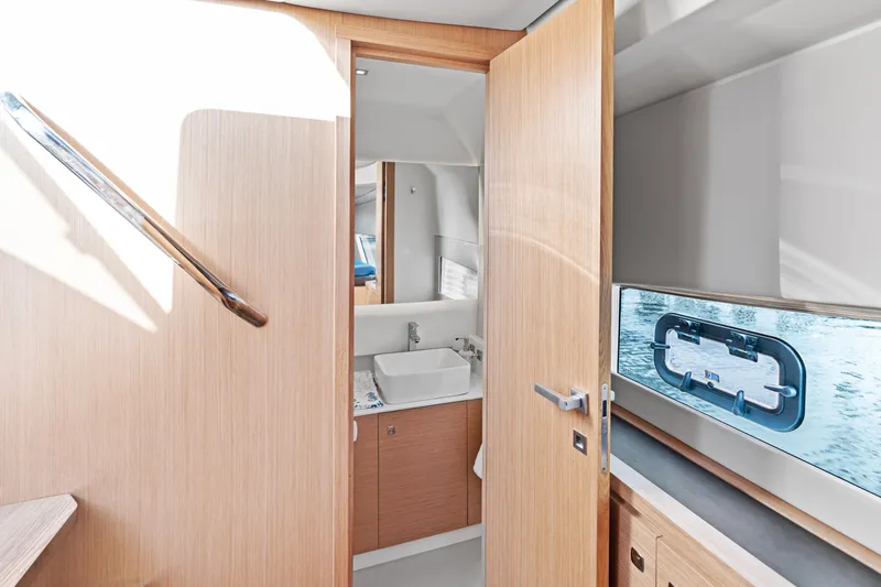  Yacht Photos Pics Interior of 2025 Makai M37 yacht bathroom with wooden door and window view.