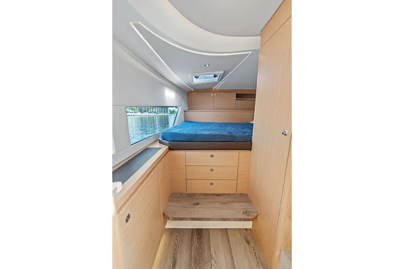  Yacht Photos Pics Luxurious interior of 2025 Makai M37 yacht with cozy bed and wooden cabinetry.
